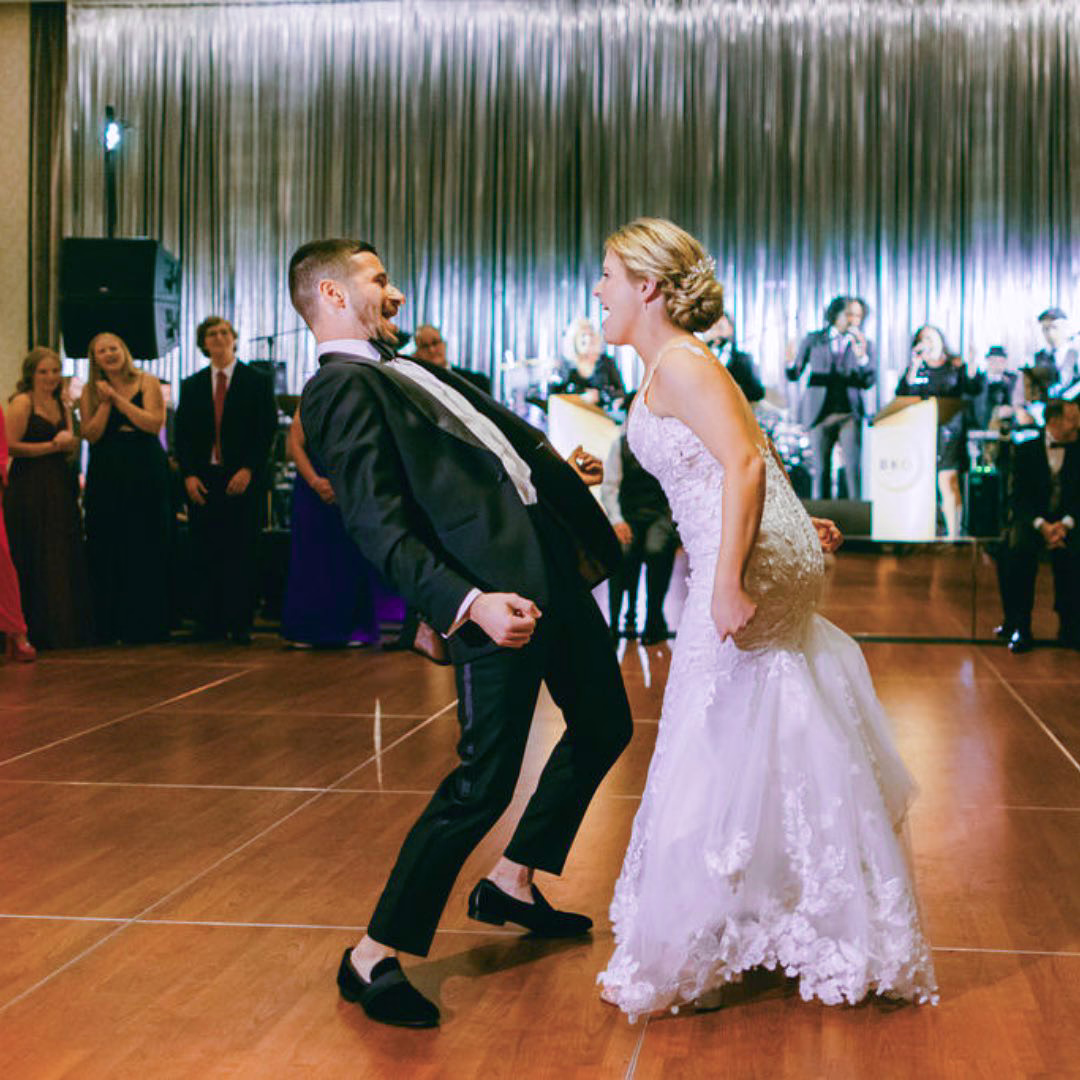 Bride and groom first dance with custom wedding arrangement